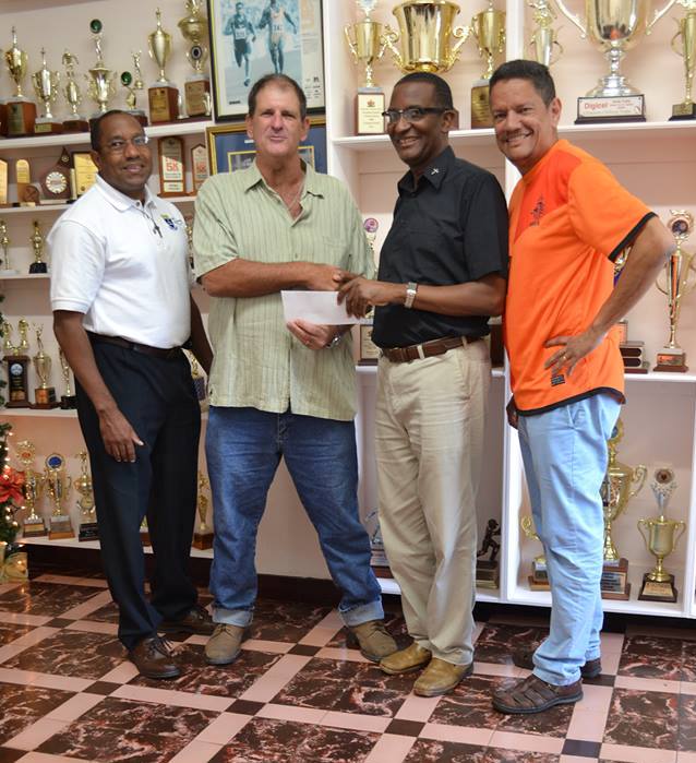 Members of the Class of 1975, from left Francis O’Neal, Christian Farfan presenting a cheque last week to Fatima Principal, Father Gregory together with Dennis Ramdeen.